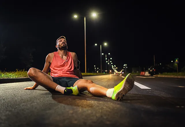 iamge of runner sitting on ground tired